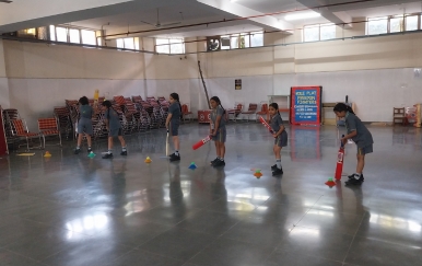 School children practising cricket skills